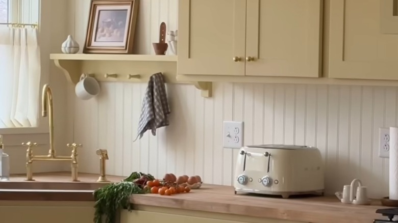 Quaint country kitchen with white backsplash and butter yellow cabinets