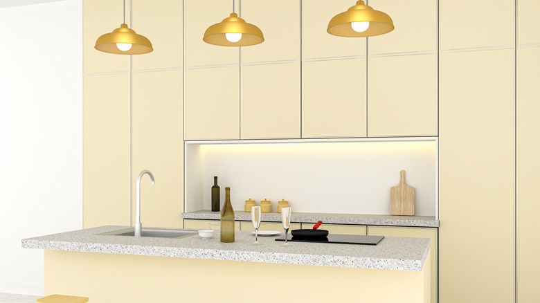 Kitchen with pale yellow cabinets and gray marble countertops