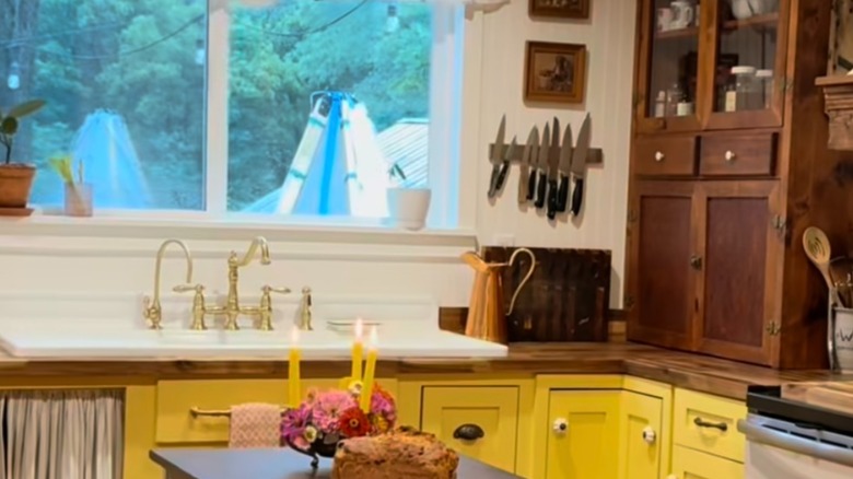 Yellow kitchen cabinets with brown wood upper cabinets