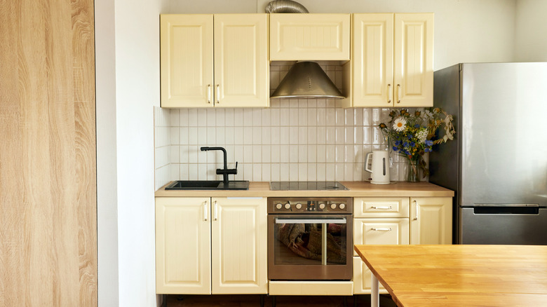 Small kitchen with butter yellow cabinets