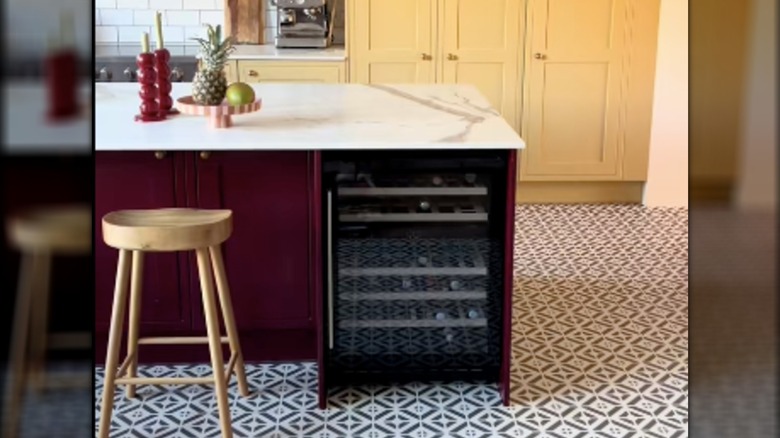 Kitchen with burgundy island and butter yellow cabinets