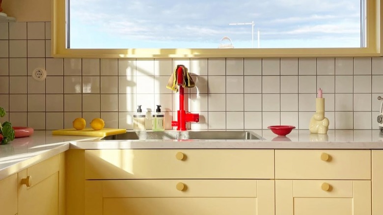Butter yellow cabinets with red kitchen faucet