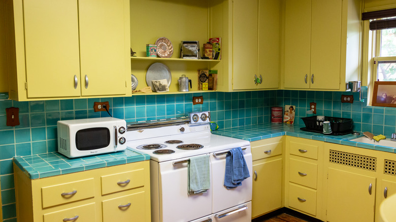 Kitchen with yellow cabinetry and blue tile counters