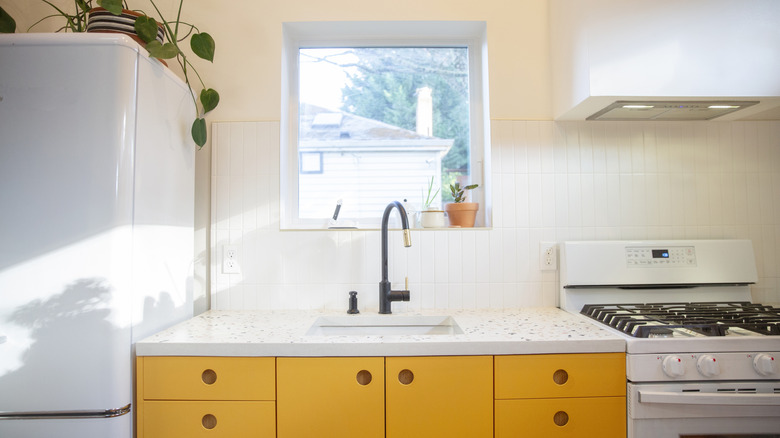 Kitchen with yellow cabinets and cream walls