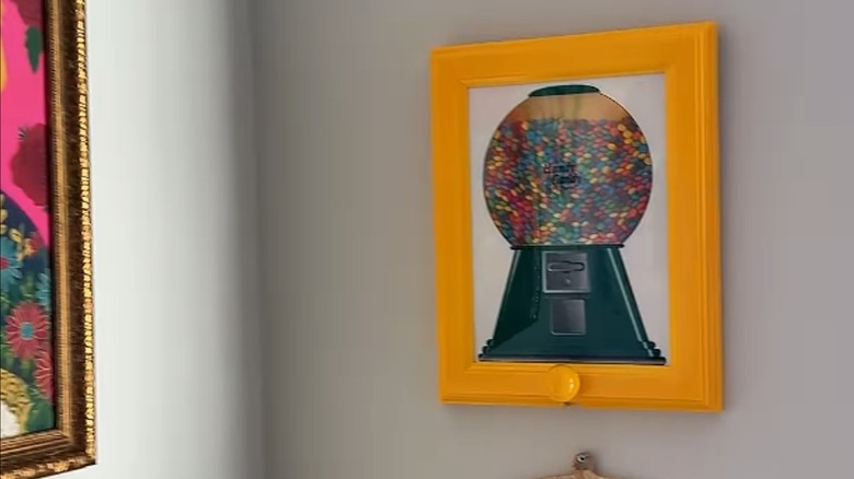 A vintage candy picture frame with candies on wall.