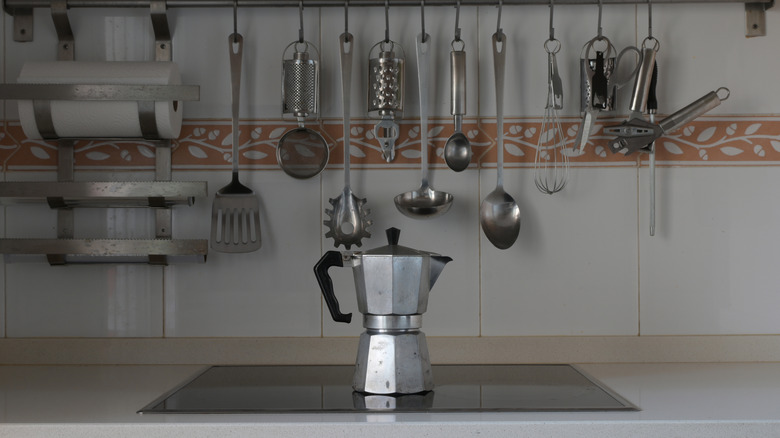 A metal stovetop coffee maker sitting on an electric stove