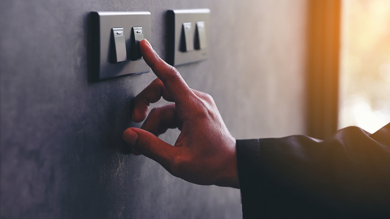 Hand touching a light switch