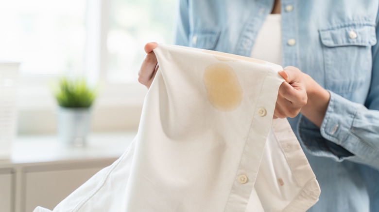 Hands holding a stained piece of white shirt