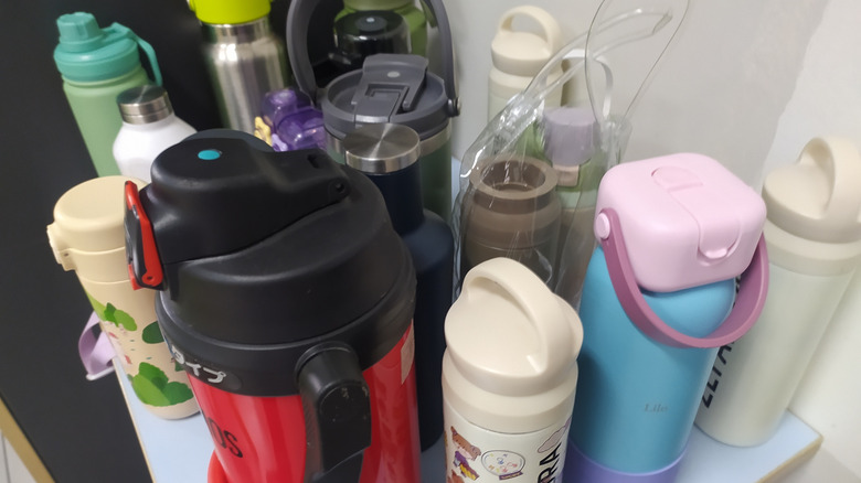 Collection of water bottles on a kitchen shelf