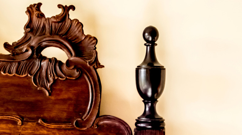 The corner of an antique headboard with finnials.