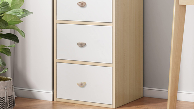 A white nightstand with agate pulls.