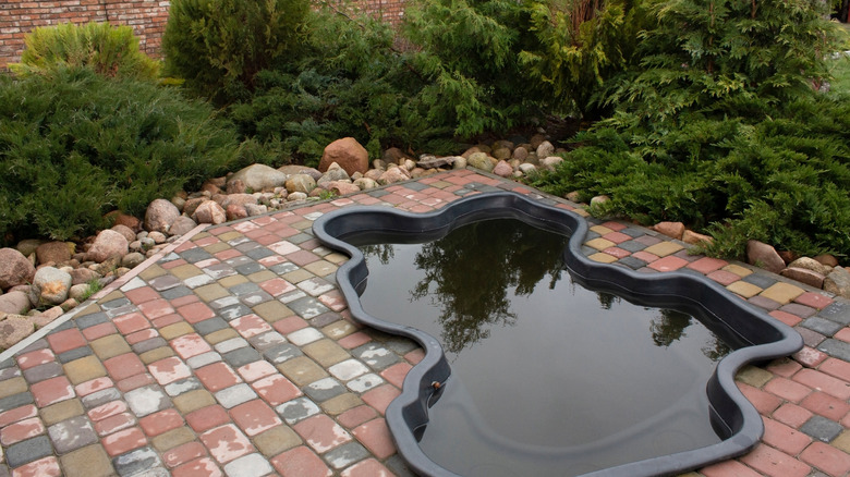 A small, curvy plunge pool in a brick courtyard area