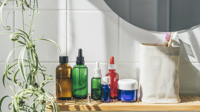 Products and toothbrushes on a floating shelf beneath a mirror