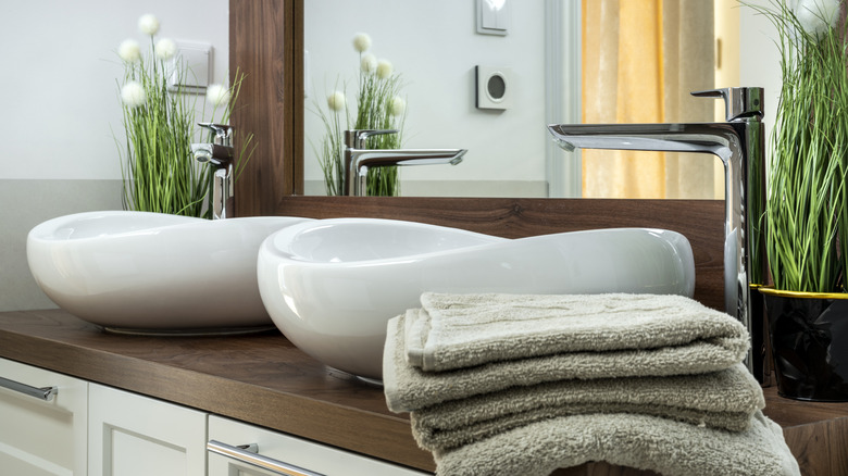 Towels on bathroom countertop with dual sinks