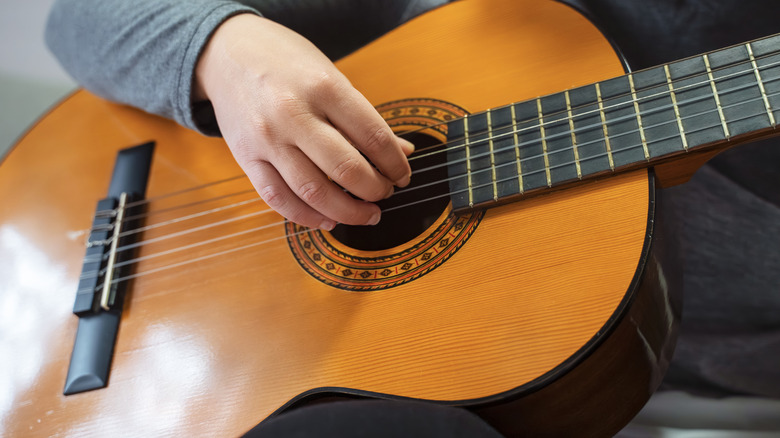 Close-up of hands playing an acoustic guitar