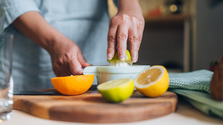 person juicing citrus fruit