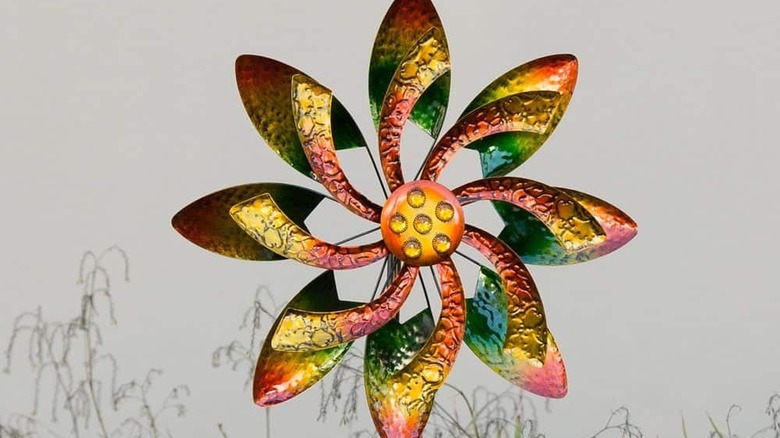 A bright, multi-colored wind spinner that resembles a flower against a gray background