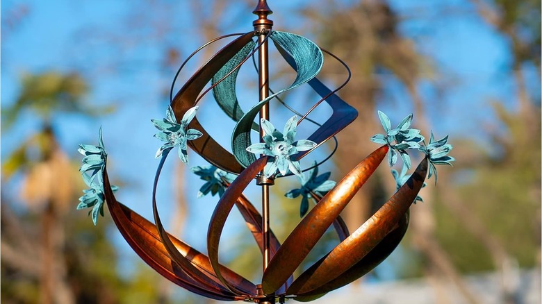 A flower-like wind spinner or windmill with copper and blue designs