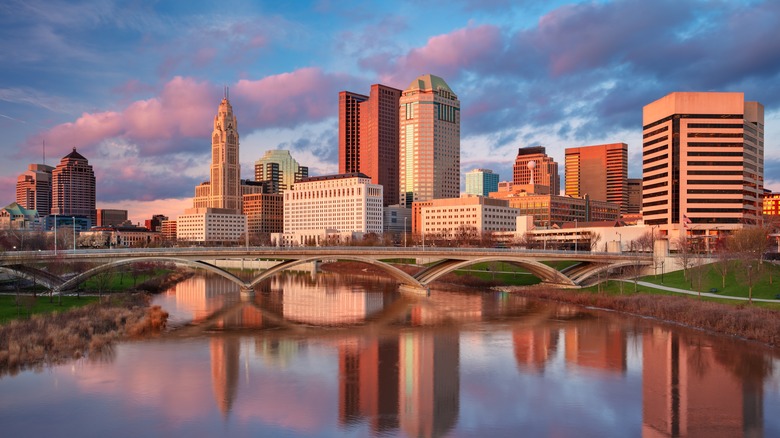 Cityscape image of Columbus, Ohio, USA downtown skyline with the reflection of the city in the Scioto River at spring sunset.