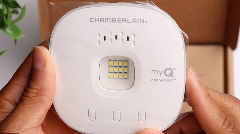 Person installing Chamberlain Smart Garage Control on garage door