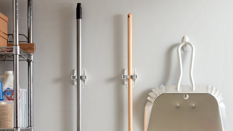 Command Broom Grippers on wall holding brooms