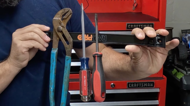 man holding RamPro Magnetic Tool Holder Strip with tools attached