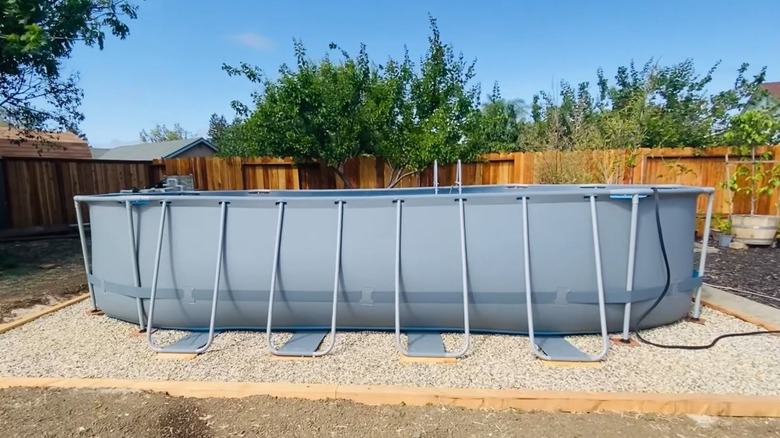 An above-ground pool with a gravel base.