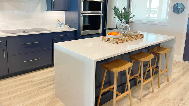 White kitchen island in a navy kitchen