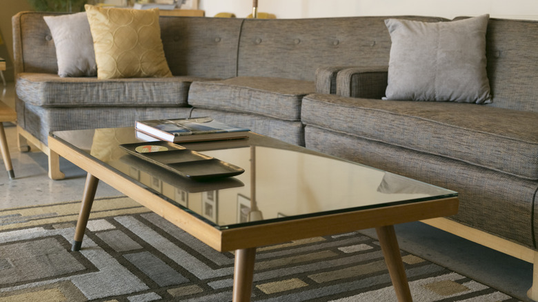 black tray on top of a coffee table next to couch