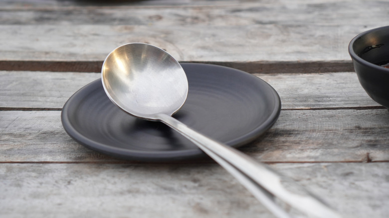 A cooking spoon resting on a small tray