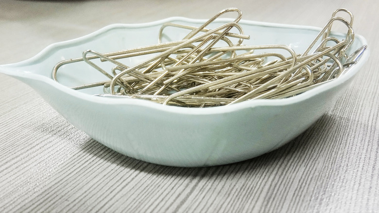 paperclips in white ceramic bowl on wood table