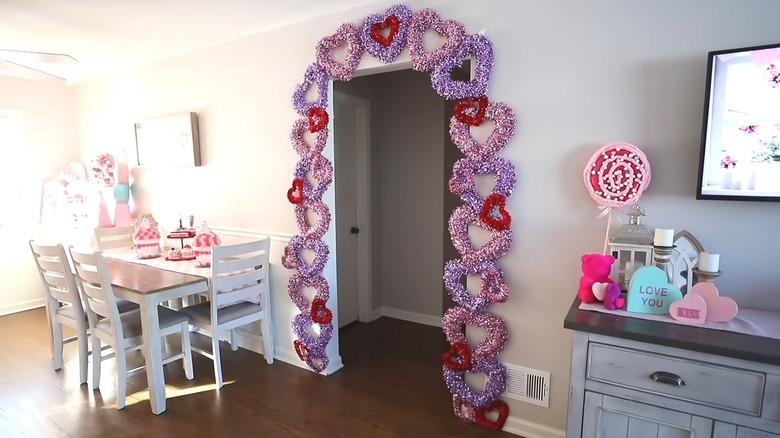 Pink, red, and purple tinsel hearts forming an arch around a doorway