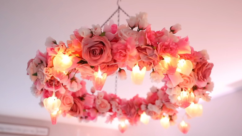 Pink floral lighted wreath with heart-shaped lights hanging from ceiling