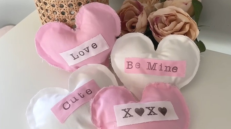 Pink and white fabric hearts sitting on a white table