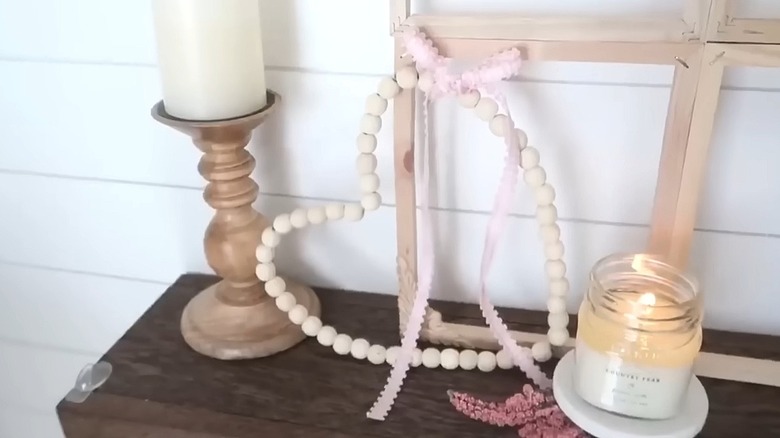 Light wood bead heart on its side with bows on it