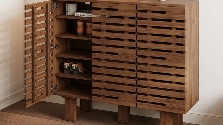 A modern cabinet in an entryway with shoes inside