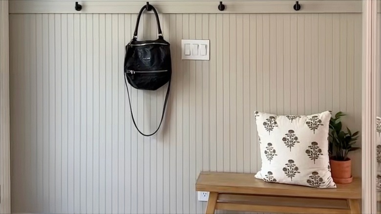Vertical shiplap wall with hooks and a bench