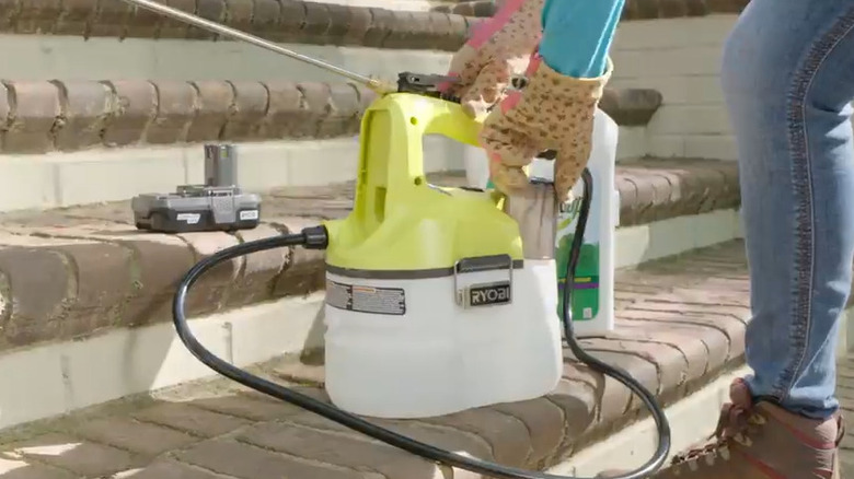 a person is filling up a 1 gallon chemical sprayer from the ryobi 18v tool lineup