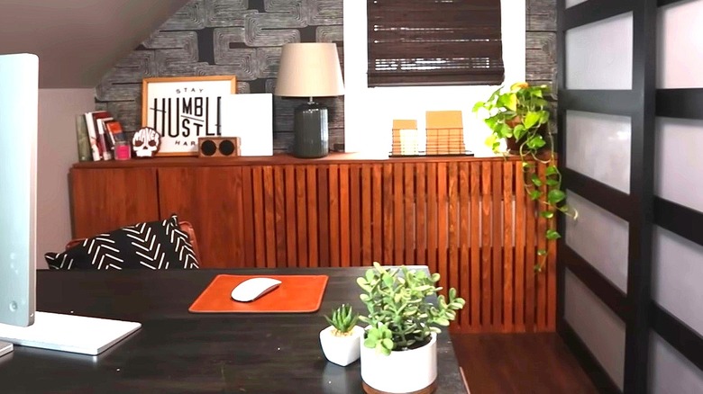 DIY wood slat radiator cover with books, lamp, and other decor on top