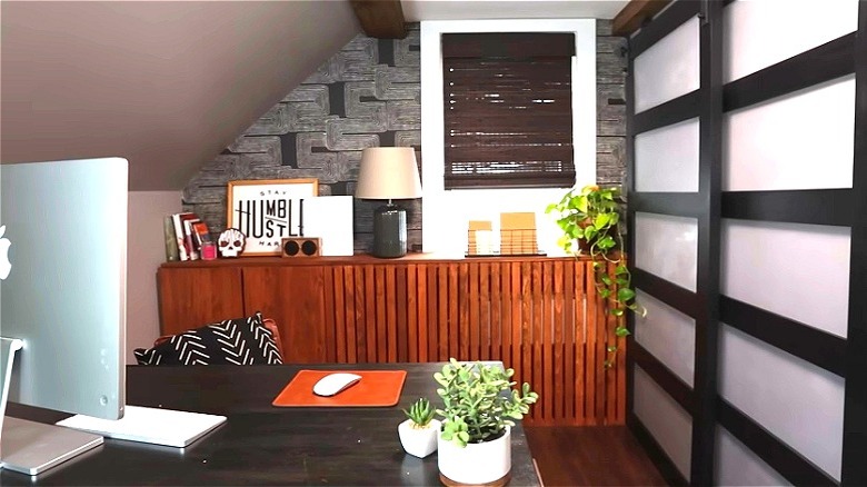 DIY wood slat radiator cover with books, lamp, and other decor on top