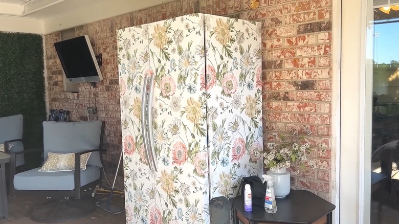 Refrigerator covered with a floral wallpaper design