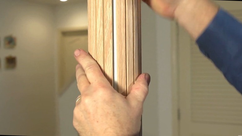 Support pole in a finished basement covered with pole wrap