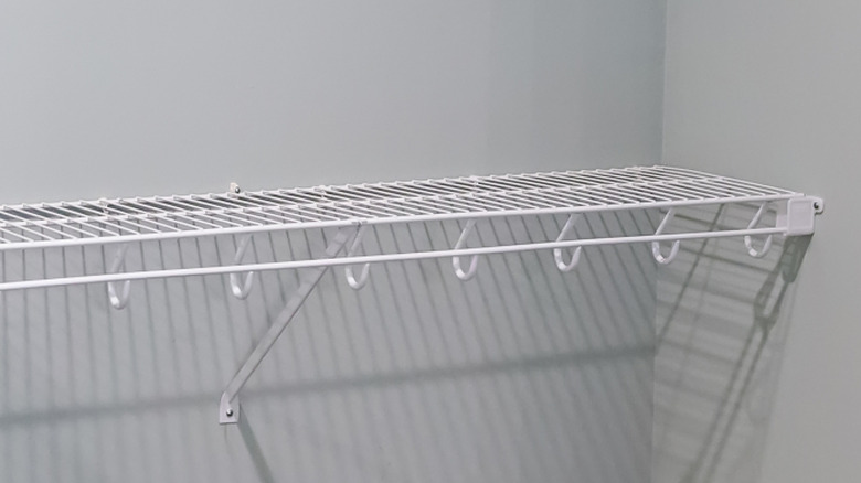 Wire shelves in an empty walk-in closet with white walls