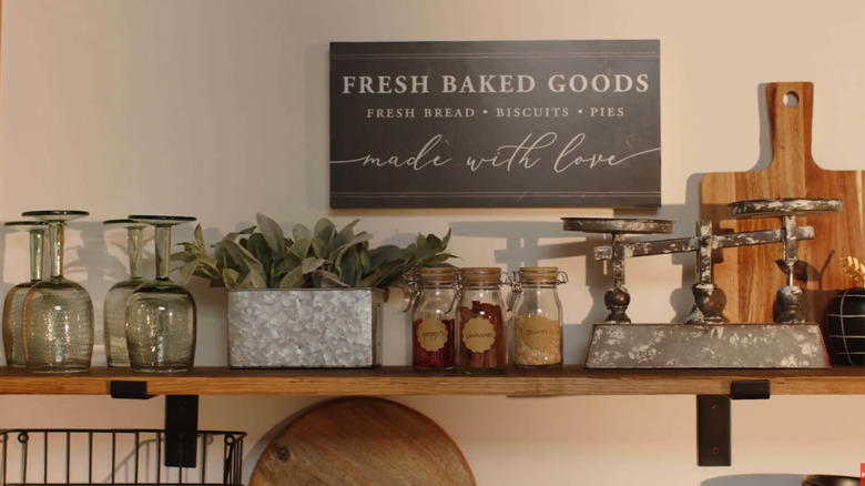 Kitchen items on a rustic wood shelf with metal brackets