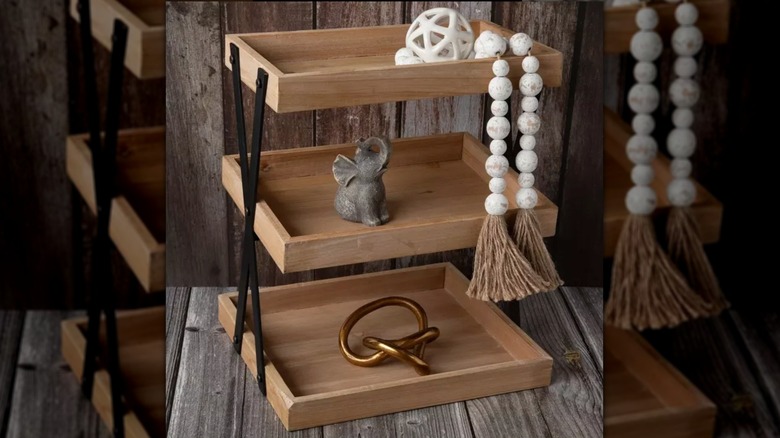 three-tiered wood shelf on a table with home decor items on it