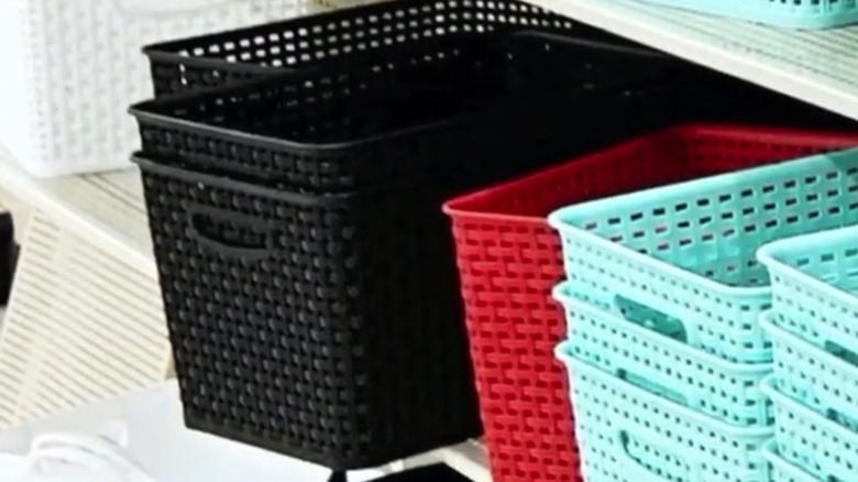 Plastic white, black, red, and blue storage bins on a shelf in a Hobby Lobby
