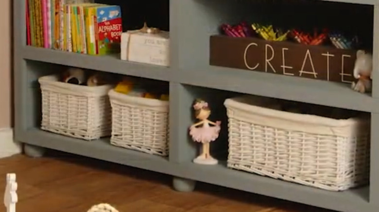 white storage bins in a shelf with toys and books