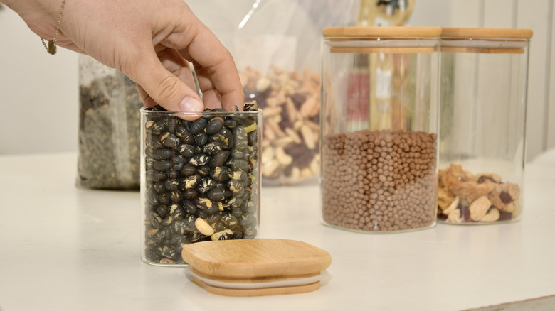 person scooping dry beans by hand