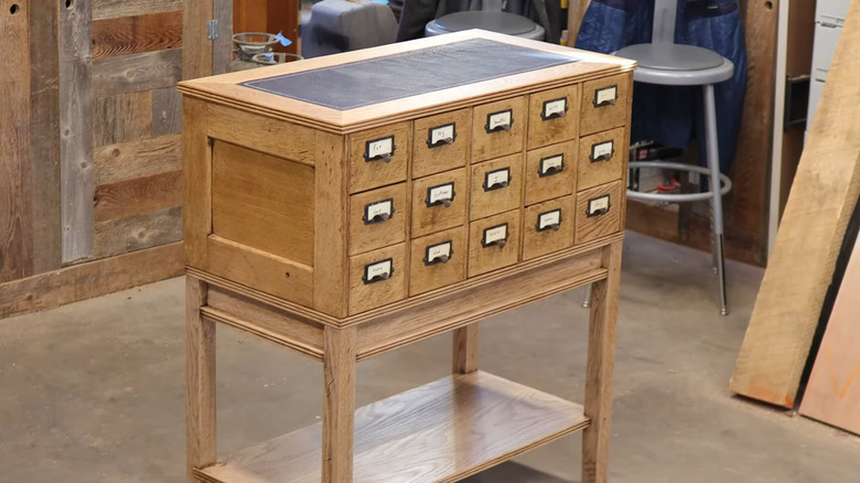 Restored wooden card catalog sitting on a base in a workshop