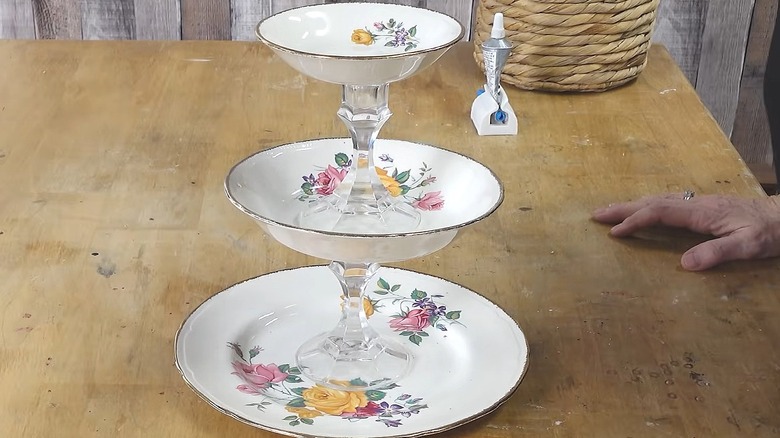 Three-tiered tray made from plates and bowls with candlestick holders as the supports
